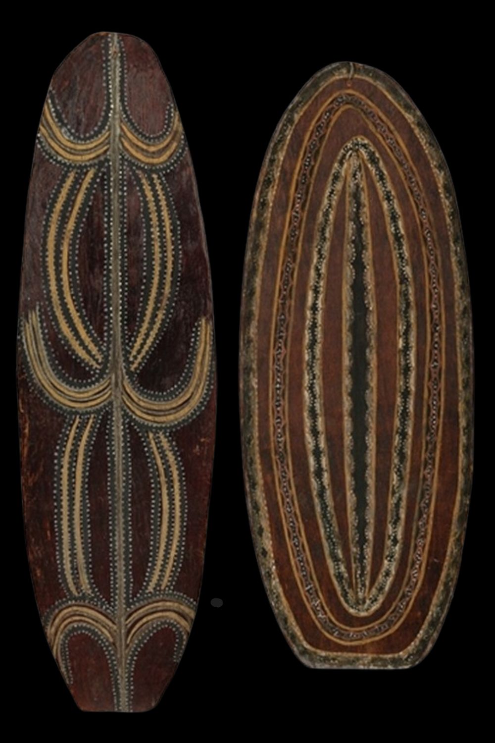 two Bark paintings by Charlie Mardigan on oval shaped pieces of bark and painted with churinga style motifs