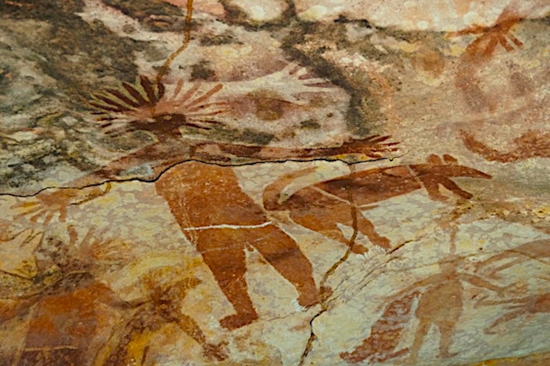 Ancient Quinkan rock painting depicting a spirit figure beside a stylised dingo in a Cape York sandstone shelter