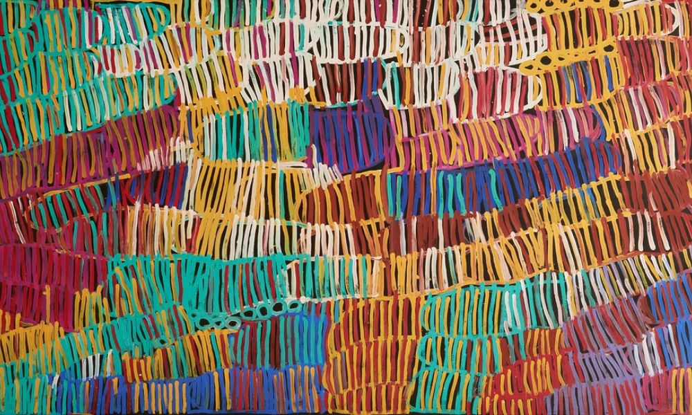 Painting by Minnie Pwerle featuring vibrant flowing lines of turquoise, yellow, red, purple, white, and orange inspired by Awelye women's ceremonies and Bush Melon Dreaming.