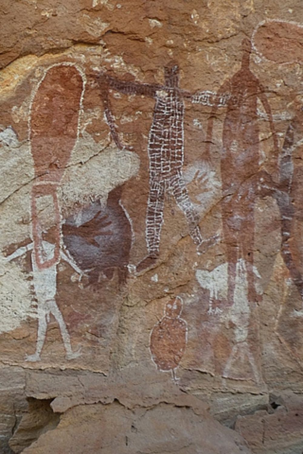 Quinkan rock painting showing elongated spirit figures with geometric body decoration in a Cape York sandstone shelter