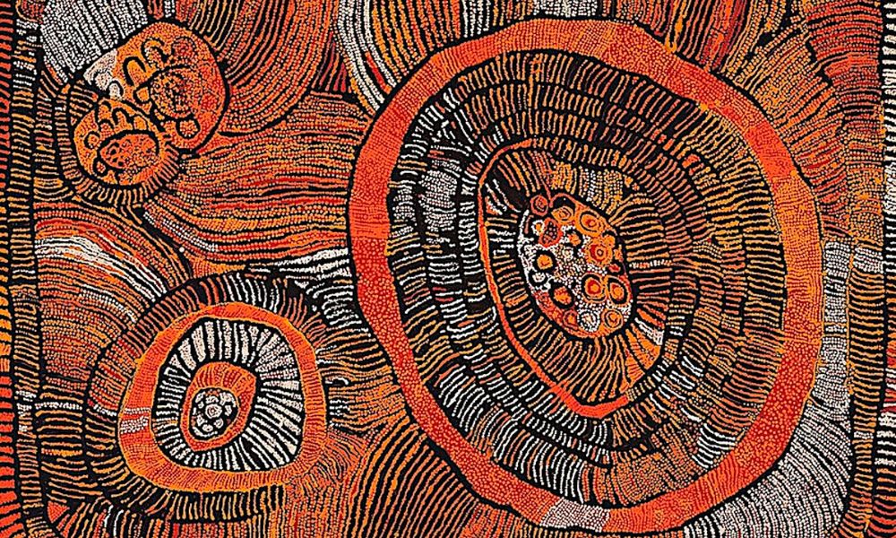 Western Desert Art painting by Naata Nungurrayi featuring concentric ceremonial forms, flowing linework, and dense dotting in rich ochre, black, orange, and white tones.