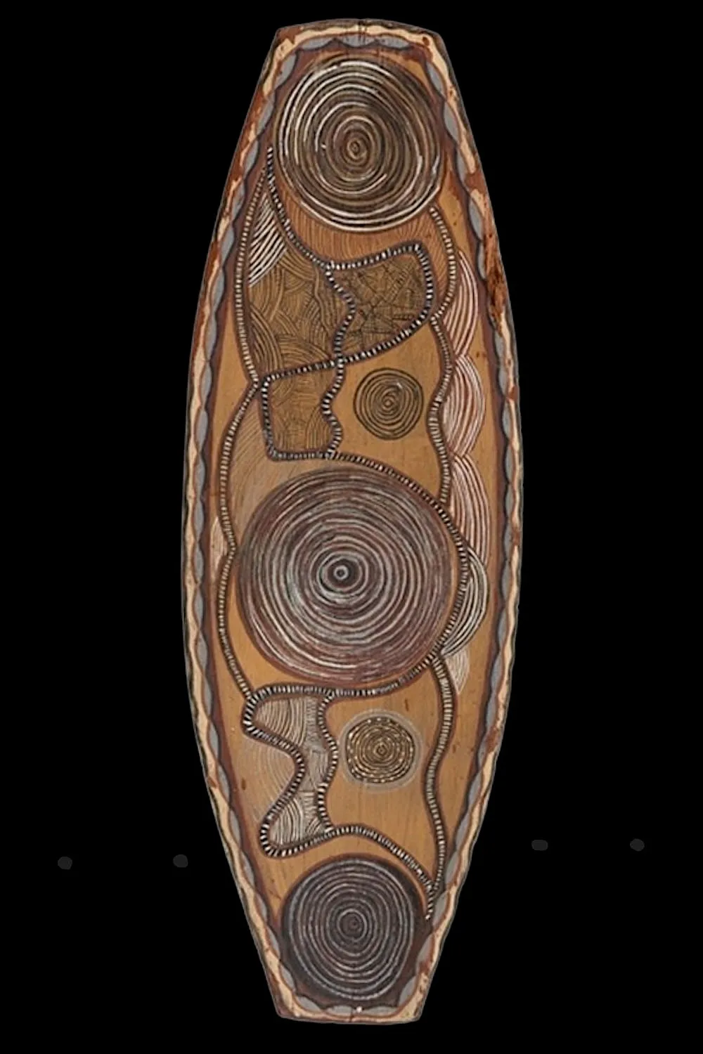 Early Port Keats bark painting on an elongated oval bark panel featuring concentric circles, journey lines, and ceremonial symbolic imagery from Wadeye.