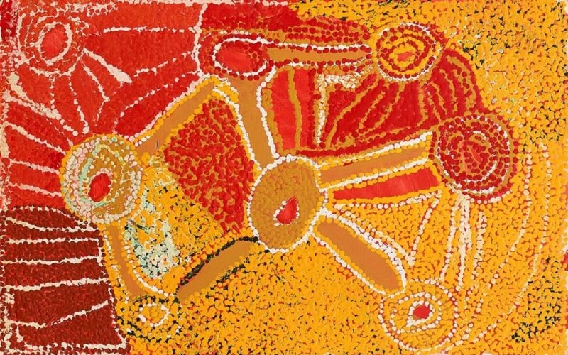 Nyilla (1992) by Eubena Nampitjin depicting the Nyilla landscape with interconnected waterholes, ceremonial sites and ancestral pathways in vibrant red and yellow tones.