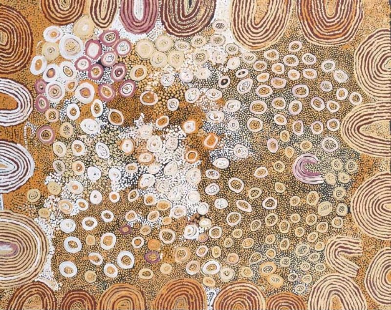 Naata Nungurrayi painting Untitled (2002), depicting concentric sandhill motifs surrounding hundreds of softly coloured circular forms on a warm ochre ground in a Western Desert composition.