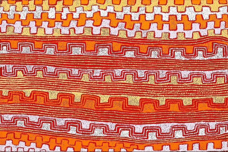 A vertical Aboriginal painting in brilliant shades of burnt orange, vivid orange, deep red, cream, white and pale yellow. Broad horizontal bands stretch across the canvas, each filled with repeating stepped motifs, parallel dotted contour lines and gently undulating pathways. The central bands are composed of thousands of closely spaced white dots that create flowing horizontal lines, while the upper and lower sections feature bold geometric patterns in alternating orange, red and cream. The warm colours shimmer against one another, giving the painting a vibrant optical rhythm that resembles rolling desert sandhills viewed from above.