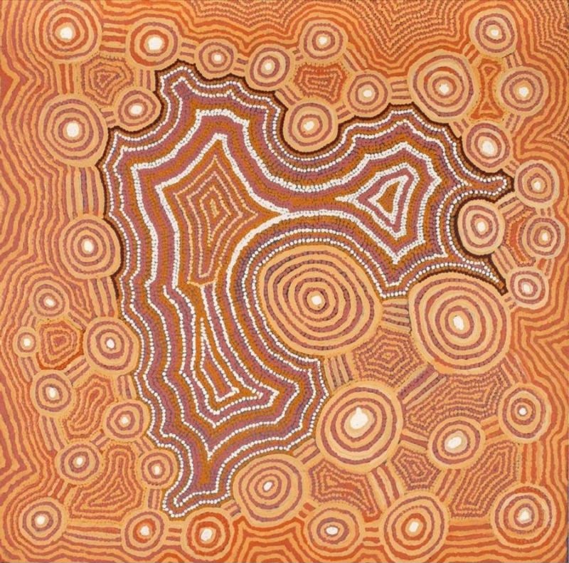 A square Aboriginal painting in soft desert colours of warm ochre, burnt orange, terracotta, cream, white and muted brown. A large irregular central landform, outlined with rows of bright white dots, dominates the composition like a rocky hill seen from above. Around it are more than thirty concentric circles of varying sizes, each built from finely painted rings in ochre, orange and cream, creating the appearance of rockholes or ceremonial sites scattered across the landscape. Flowing contour-like lines fill every remaining space, curving around the circles and central form to produce a rhythmic, map-like surface. Small diamond-shaped motifs appear between the larger forms, while the tightly packed lines and dots create a sense of movement and depth across the painting.