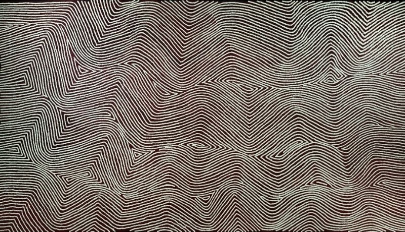 Untitled by Warlimpirrnga Tjapaltjarri, 2003. A wide horizontal painting in black, white and soft grey. Thousands of tiny white dots form flowing parallel lines that sweep across the canvas in broad waves and sharp angular turns. The lines merge and separate to create shimmering zigzags and undulating bands, giving the impression of wind moving across sand dunes or the contours of a vast desert landscape viewed from above.