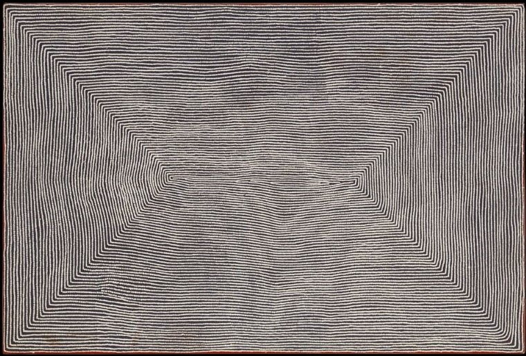 Wilkinkarra (Lake Mackay) by Warlimpirrnga Tjapaltjarri, 2004. A large horizontal painting in black, white and soft grey. Thousands of tiny white dots form uninterrupted horizontal lines flowing across the canvas. The lines converge from all four sides towards a narrow central opening, creating two immense triangular forms that appear to fold into the centre. The subtle changes in direction create a hypnotic optical illusion reminiscent of wind sweeping across an immense desert plain or a vast aerial view of the landscape.