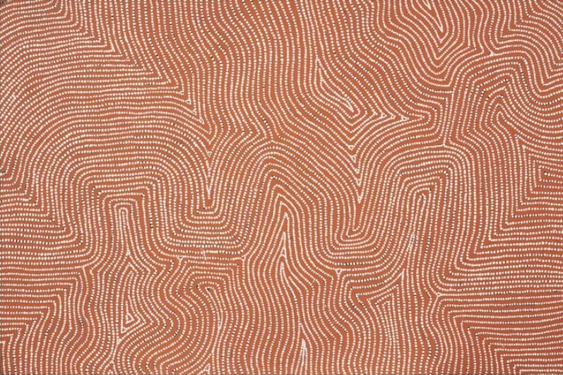 Untitled (Designs Associated with the Rockhole Site of Tjuntulpul) by Warlimpirrnga Tjapaltjarri, 1999. A horizontal painting in soft pink, pale terracotta and white. Thousands of tiny white dots form flowing parallel lines that meander across the canvas, creating broad zigzags, rounded bends and angular pathways. The subtle tonal variations produce a shimmering, almost hypnotic surface resembling wind-shaped desert sand viewed from above.