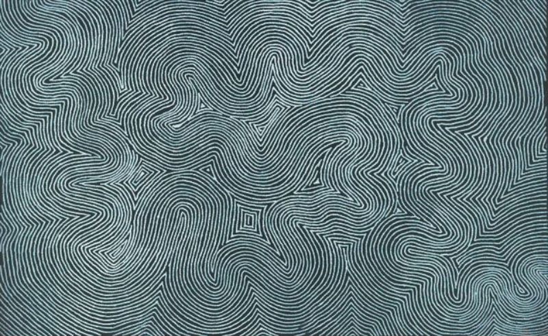 Tingari Cycle by Warlimpirrnga Tjapaltjarri, 2005. An abstract Aboriginal painting composed of thousands of fine ochre-yellow dots arranged in continuous lines across a deep black background. The lines flow through broad angular pathways, sharp turns and stepped geometric forms, creating a maze-like pattern with a powerful sense of movement and depth. The strong contrast between the glowing ochre dots and the black ground gives the painting a luminous, almost pulsating appearance.