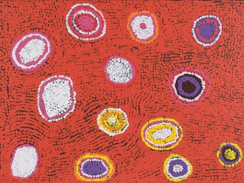 Untitled (2006) by Tommy Watson, synthetic polymer paint on linen featuring concentric circular forms in white, pink, purple and yellow against a vibrant red dotted ground.