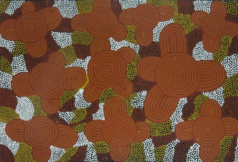 Untitled by Warlimpirrnga Tjapaltjarri, 1996. A vertical painting in warm desert colours of burnt orange, reddish brown, olive green and bright white. Large four-lobed ceremonial motifs resembling flowers or cross-shaped forms are scattered across the surface. Each contains finely painted concentric circles at its centre. The background is filled with dense fields of small white, green and brown dots, creating a rich, textured surface with a strong sense of rhythm and depth.