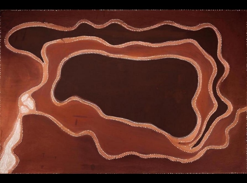 Rover Thomas ochre painting with a large dark central shape surrounded by looping red and brown bands edged with fine white dots.