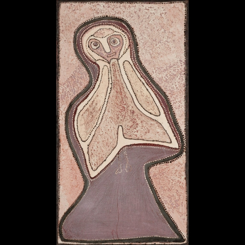 Rover Thomas painting of a large owl-like figure filling a tall narrow canvas. The bird has a rounded head with two circular eyes, a long pale beak and broad cream wings outlined with dark dots. Its body rises from a large purple-brown base, surrounded by mottled pink, cream and earthy brown pigment.