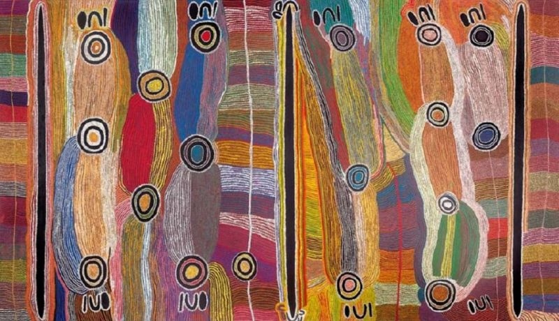 Maggie Watson Napangardi painting with tall black digging-stick forms and elongated multicoloured shapes containing circular motifs, set against flowing vertical fields of red, blue, green, orange, pink and white lines.