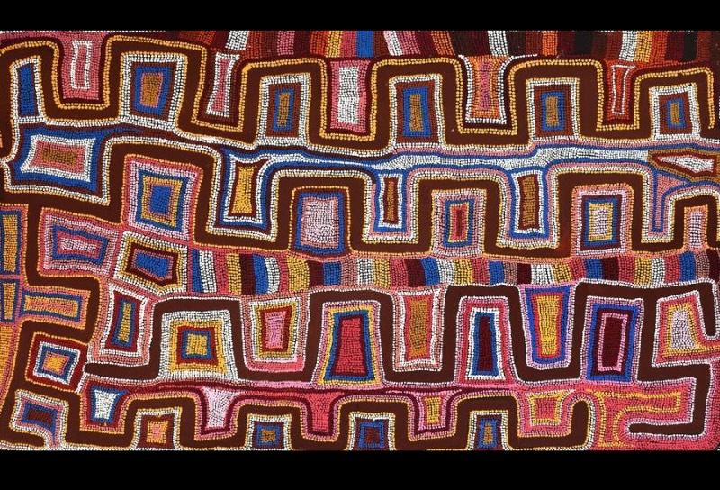 Boxer Milner’s Sturt Creek (1993), with interlocking geometric forms and dense dotting in red, pink, blue, yellow, white and brown across a horizontal canvas.