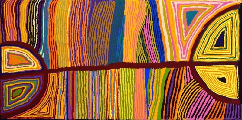 Aboriginal painting by Judy Napangardi Watson featuring dense vertical bands of orange, yellow, pink, blue, green and purple crossed by a dark horizontal line connecting large semicircular forms filled with concentric geometric designs.