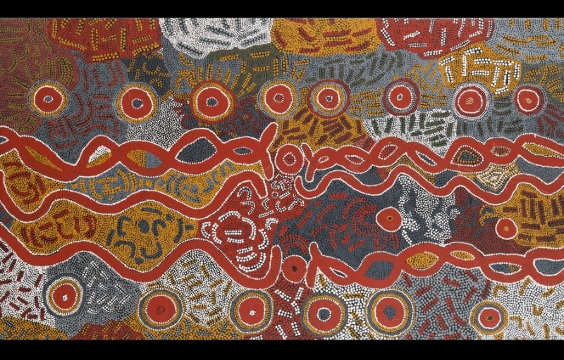 Maggie Watson Napangardi painting with long interlocking red and white pathways running across dense fields of ochre, grey, black and white dots, surrounded by repeated concentric circular motifs.