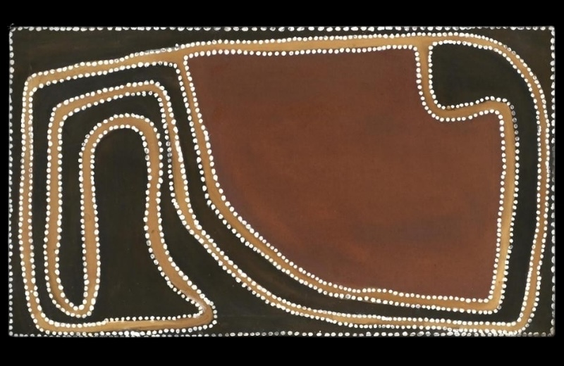 Rover Thomas painting of a small creek in black, brown and golden ochre. A narrow winding black channel loops tightly through the left side before curving around a large reddish-brown field on the right. Golden ochre bands and closely spaced white dots trace the creek and surrounding boundaries.