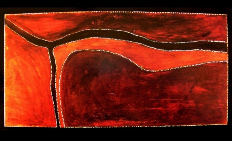 Abstract ochre landscape by Rover Thomas with broad red and dark brown areas divided by a winding black river-like band edged with fine white dots.