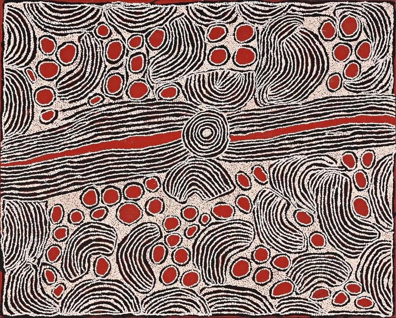 Red, black and white Aboriginal painting by Ningura Napurrula with a large concentric circle at the centre crossed by a broad horizontal band of closely spaced black and white lines containing a narrow red channel. Above and below are clusters of bright red oval shapes surrounded by sweeping curved and semicircular bands of black and white lines.