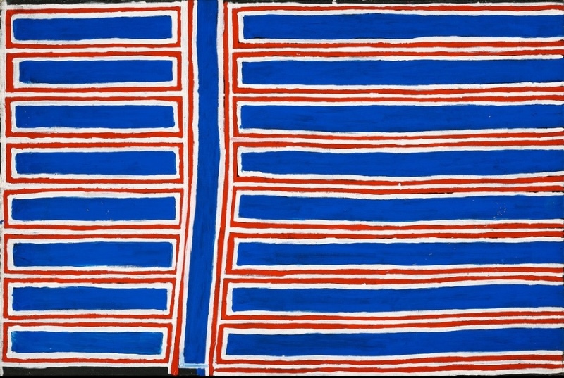 Boxer Milner’s Purkitji (2003), with a strong vertical blue channel dividing repeated horizontal blue bands outlined in white and red across the canvas.