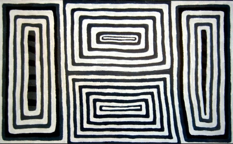 Ronnie Tjampitjinpa’s Untitled (1992), featuring four bold rectangular motifs formed from repeated concentric black and white bands, arranged across a horizontal canvas.
