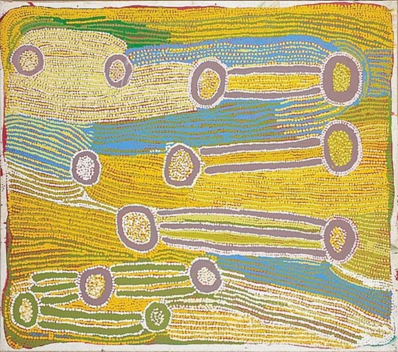 Maggie Watson Napangardi painting with elongated digging-stick forms connecting circular motifs across flowing fields of yellow, green, blue and white dots.