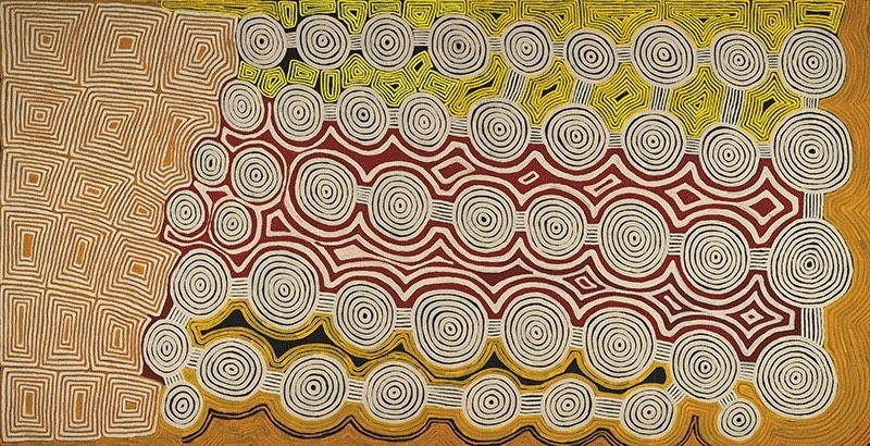 Ronnie Tjampitjinpa’s Kumpuralgna (1996), a monumental horizontal painting filled with concentric circles, interconnected lines and dense rectangular geometric patterns in white, red, yellow and ochre.
