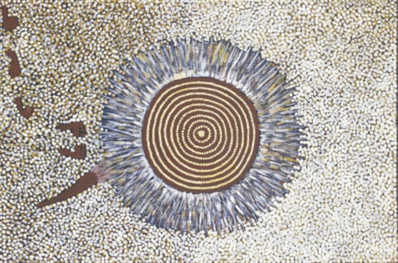 Turkey Tolson Tjupurrula Untitled, 1994. Aboriginal painting showing a large concentric circle surrounded by radiating blue-grey strokes on a densely dotted white background with footprints and a spear at the left.