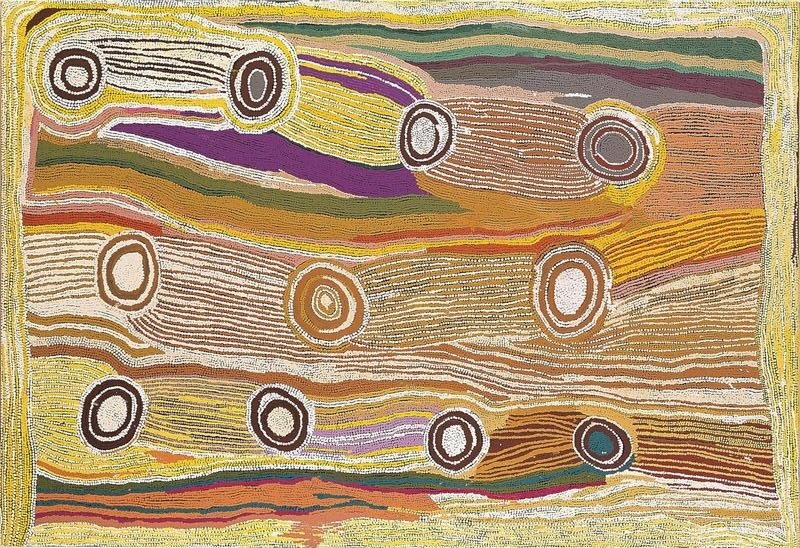 Maggie Watson Napangardi painting with concentric circular motifs distributed across broad flowing bands of fine yellow, white, ochre, green, purple and orange lines, with elongated forms linking several circles.