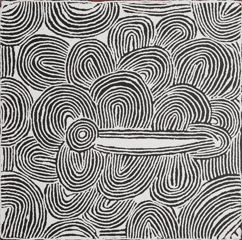 Black and white Aboriginal painting by Ningura Napurrula filled with bold parallel lines curving into overlapping arches, loops and rounded forms. Near the lower centre-left, a concentric circle joins a long horizontal white shape outlined in black that extends across the composition, surrounded by densely layered curved patterns.
