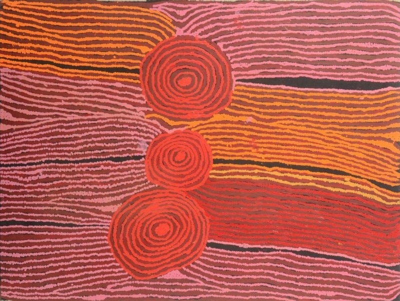 Pink, orange, red and dark brown Aboriginal painting by Ningura Napurrula dominated by three red concentric circles arranged vertically near the centre. Broad fields of closely spaced parallel lines flow horizontally around the circles in alternating pink, orange and red, with irregular dark channels separating some of the bands.