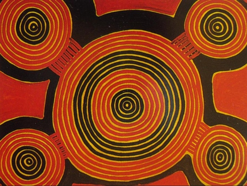 Ronnie Tjampitjinpa’s Tjilkamatu (Echidna) Dreaming at Tukun (1994), featuring a large central concentric circle connected to four smaller circular forms in vivid red, black and yellow.