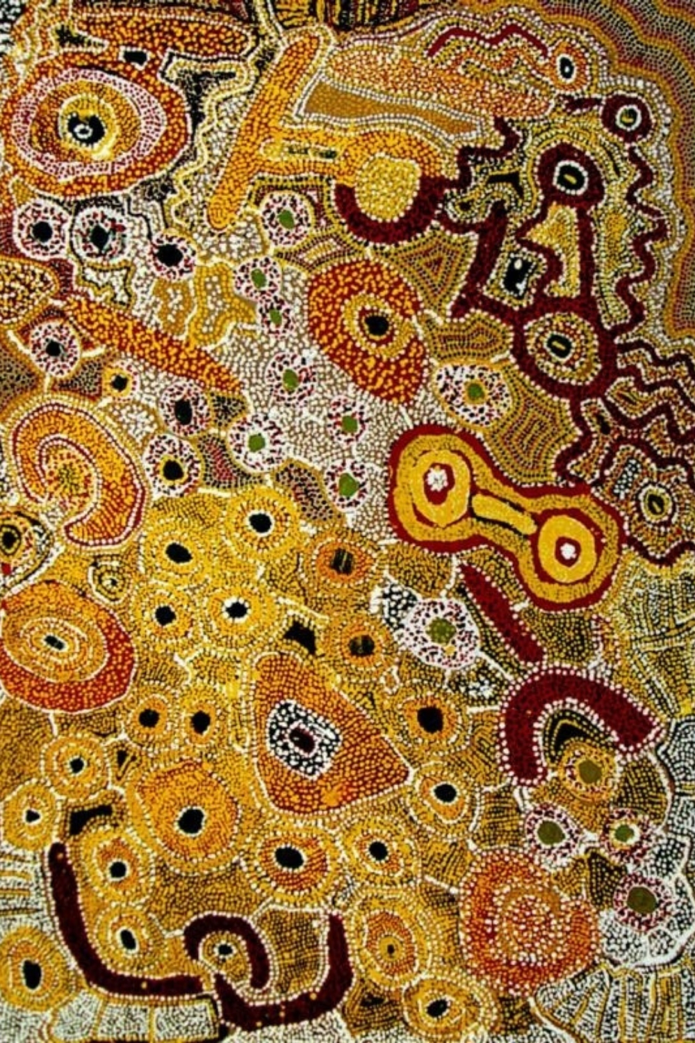 Wimmitji Tjapangarti painting with dense fields of yellow, red and white dots surrounding circular forms, pathways and irregular geometric shapes.