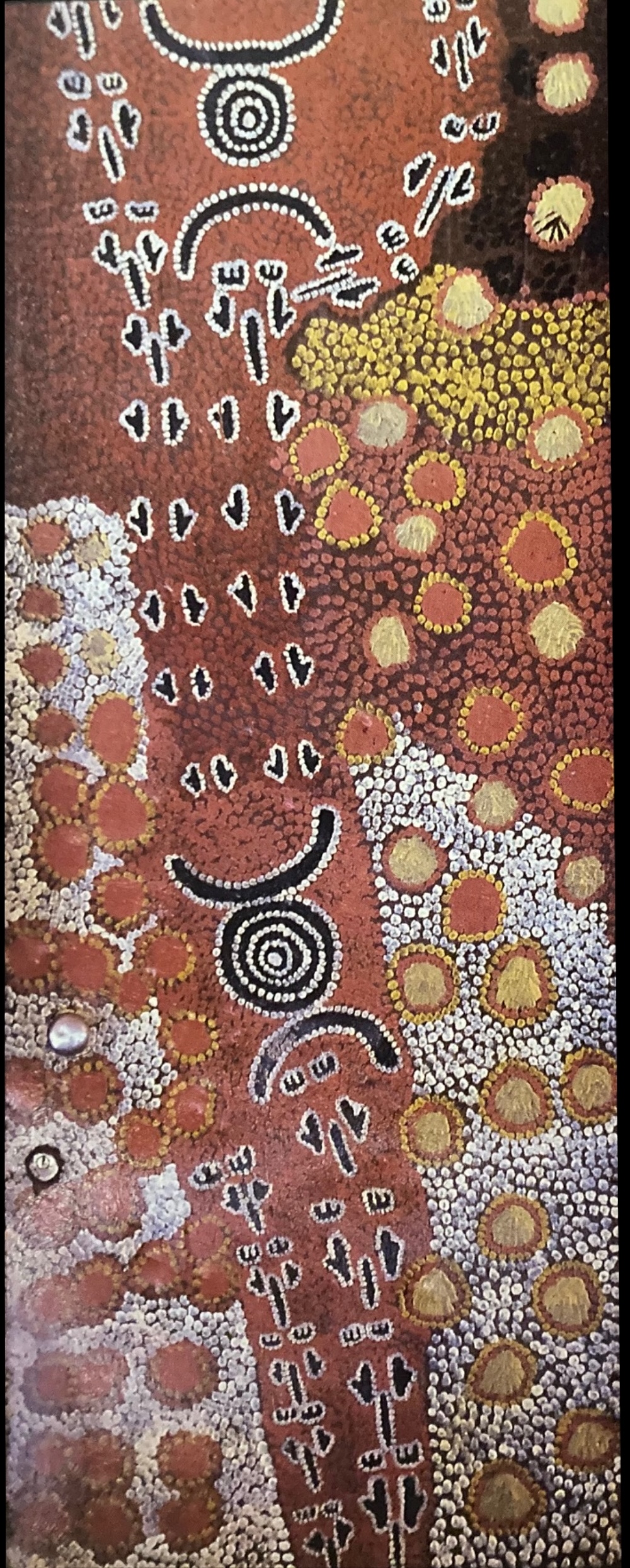 Yuendumu School Door painting by Paddy Japaljarri Stewart, with concentric circles, animal-track motifs and dense fields of white, ochre, yellow and red dotting.
