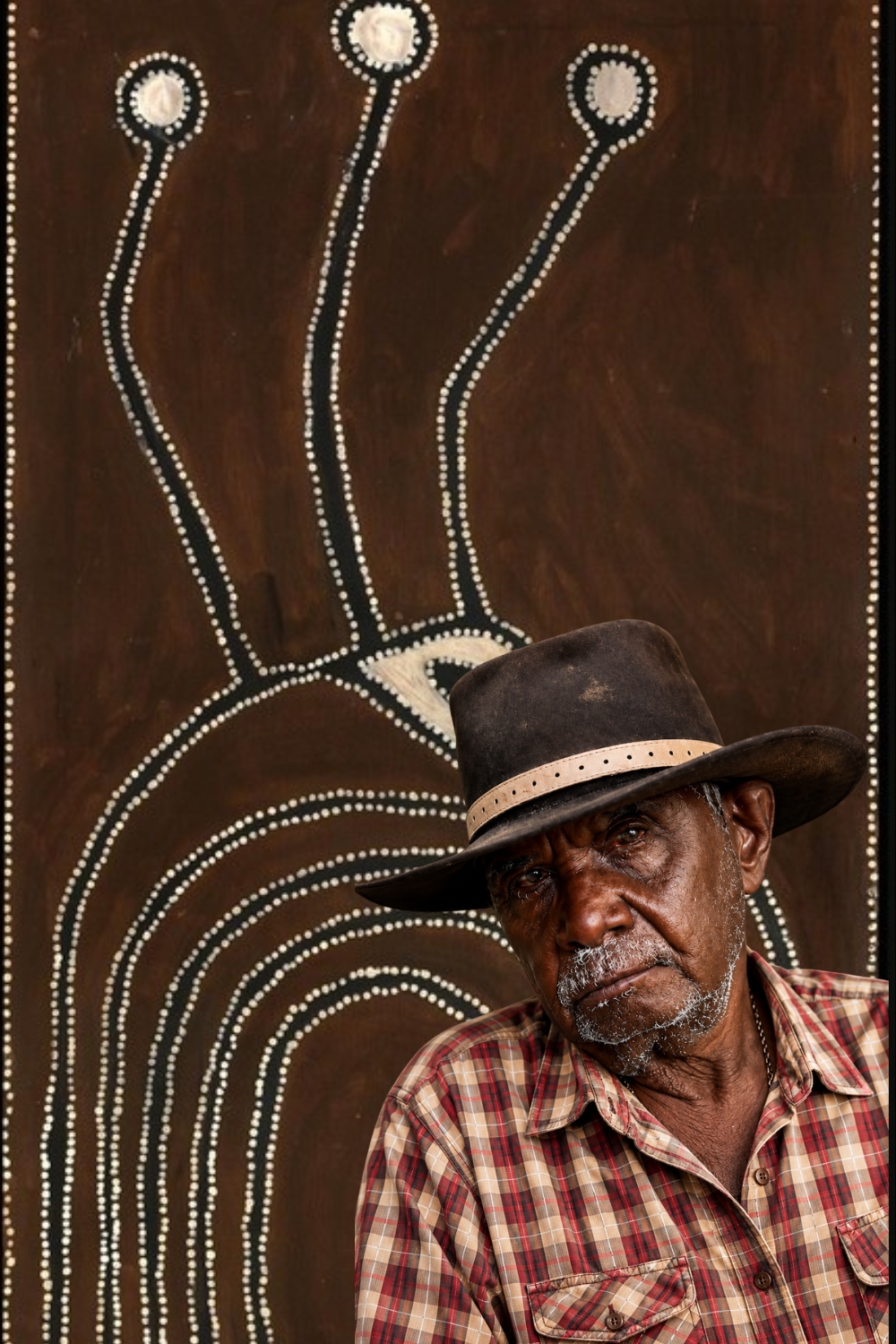 Paddy Jaminji, senior Kija artist and founding East Kimberley painter, pictured in front of one of his ochre paintings.