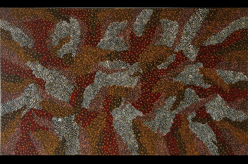 Painting by Gloria Petyarre with irregular white, ochre, red and pink shapes formed from thousands of tiny dots across a dark brown ground.