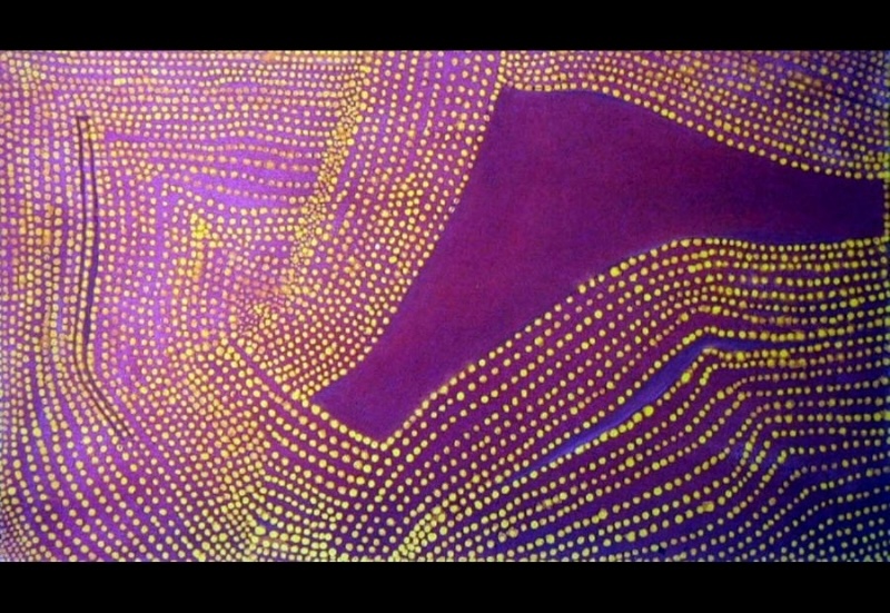Rover Thomas painting dominated by vivid purple and magenta, covered with dense flowing rows of yellow and pale dots. The dotted lines curve, bend and converge across the canvas, leaving a large irregular area of uninterrupted deep purple near the upper right.