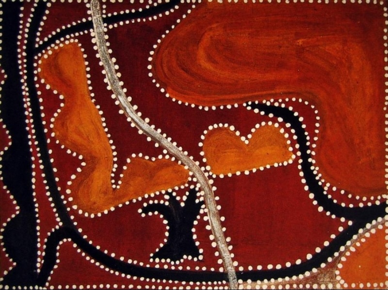 Rover Thomas painting in deep red-brown, orange and black ochres, filled with irregular landforms outlined by rows of white dots. Black branching shapes curve through the composition, while orange forms occupy the left, centre and upper right. A narrow pale vertical band runs from top to bottom near the centre.