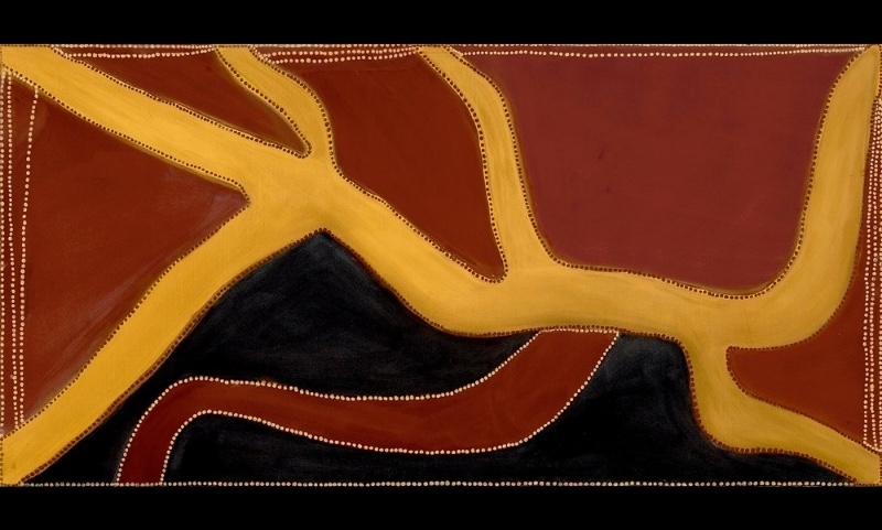 Rover Thomas painting of branching river systems in golden yellow ochre across a red-brown landscape. Broad yellow waterways fork and curve from the upper left across the canvas, surrounding a large black area below. A curved red tributary crosses the black field, while fine rows of white and dark dots outline the rivers and frame the painting.