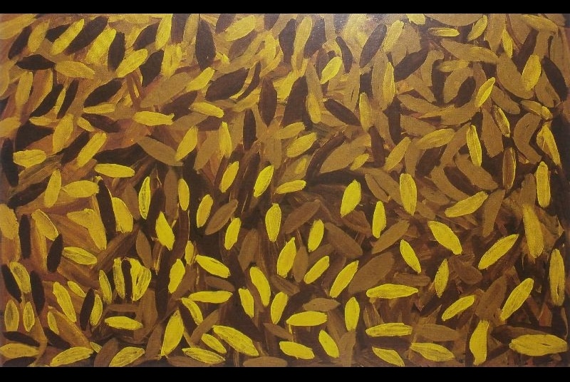 Painting by Gloria Petyarre showing hundreds of loose yellow, ochre and dark brown leaf-shaped brush marks scattered across a brown ground.