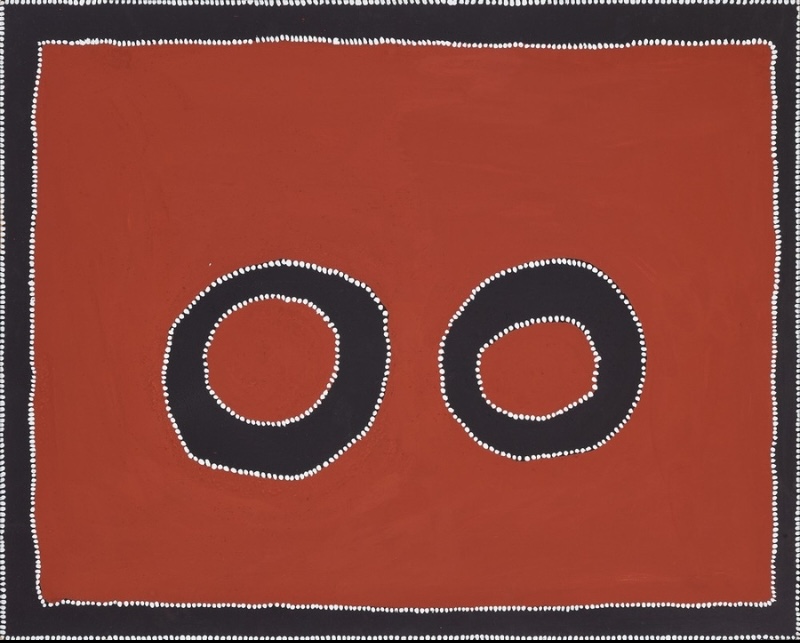 Rammey Ramsey painting on a deep red-ochre ground with two large black circular rings at the centre. The rings and the rectangular border are edged with precise rows of small white dots.