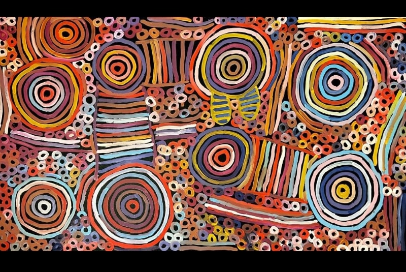 Minnie Pwerle painting filled with large multicoloured concentric circles, striped bands and hundreds of small ring-like marks in pink, orange, blue, yellow, purple and white.