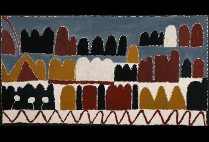 Queenie McKenzie ochre landscape with rows of red, yellow, black and white hills beneath a blue-grey sky and a winding road below.