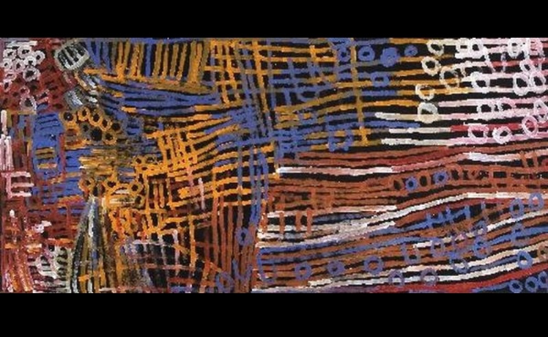 Large Minnie Pwerle painting of dense blue, orange, brown, white and pink lines, grids and circular marks extending horizontally across a black background.