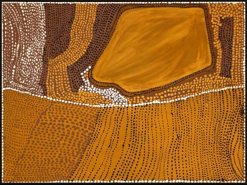 Rover Thomas painting in golden yellow, orange and brown ochre, divided into large irregular areas filled with different patterns of dots. A broad golden shape dominates the upper centre, surrounded by dense black, brown, yellow and white dotting. Across the lower half, flowing vertical rows of black dots cover a bright orange field.