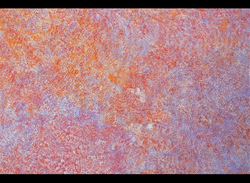 Large painting by Angelina Pwerle filled with dense fine marks in orange, red, pink, pale blue and white, forming softly merging fields of colour.