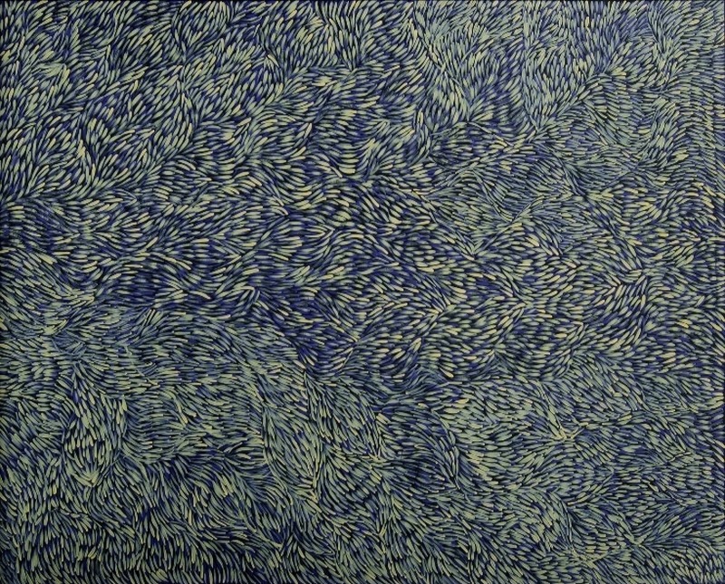 Gloria Petyarre painting densely filled with thousands of pale green leaf-shaped brush marks flowing and swirling across a deep blue ground.