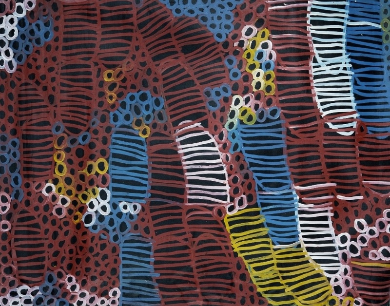 Minnie Pwerle painting densely filled with elongated striped forms and clusters of small rings in red-brown, blue, white, yellow and pink against a black ground.
